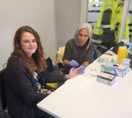 (L-R): Greymouth Probation Officer Hayley Thomas does a quick fingerprick Hepatitis screening test with Nurse Gina Vente-Smith.